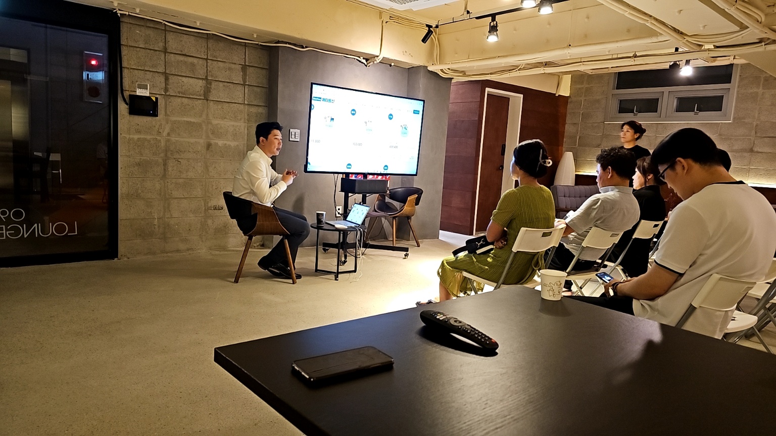 대표님이 참석자들 앞에서 판매 화면을 설명하는 소규모 교육 현장